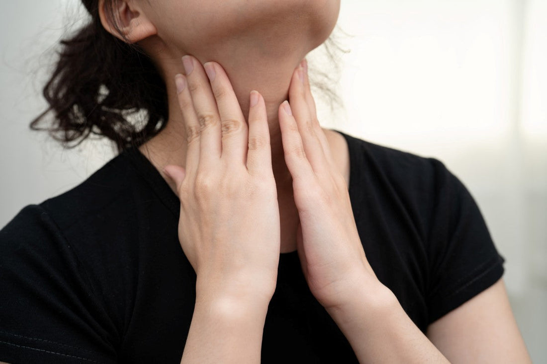 woman touching her neck and throat thyroid gland